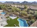 Aerial view of backyard oasis featuring pool, fire pit, and desert landscaping at 18841 N 94Th Way, Scottsdale, AZ 85255