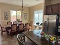 Open concept kitchen and dining area with wood cabinetry, stainless steel appliances, and tile floors at 3333 E Powell Pl, Chandler, AZ 85249