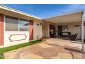 Covered patio area with seating, flagstone pavers, artificial turf, and exterior shutters at 10330 W Desert Forest Cir, Sun City, AZ 85351