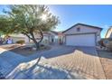 House exterior showcasing a brick driveway and mature tree at 19776 N Harris N Dr, Maricopa, AZ 85138