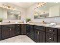 Modern bathroom with dual vanities, dark wood cabinets, and updated light fixtures at 26201 S Sherbrook Dr, Sun Lakes, AZ 85248