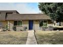 Front exterior of a single-story home with a blue door, brick and wood siding, and a landscaped yard at 4905 S Willow Dr, Tempe, AZ 85282