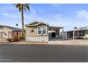 Tan single-wide manufactured home with carport and partial view of neighbor's home at 8865 E Baseline Rd # 1129, Mesa, AZ 85209