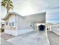 Front exterior of a manufactured home with a covered carport and storage shed at 8865 E Baseline Rd # 1129, Mesa, AZ 85209