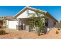 Front view of a single story house with white exterior and landscaping at 15936 W Latham St, Goodyear, AZ 85338