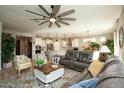 Inviting living room featuring comfortable seating, a ceiling fan, and an open view to the kitchen at 27421 W Pontiac Dr, Buckeye, AZ 85396