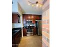 Modern kitchen featuring stainless steel appliances, dark wood cabinets, and tile flooring at 3302 N 7Th St # 226, Phoenix, AZ 85014