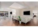 Spacious living room with white sectional sofa, wood floors, and access to the bedroom at 7151 E Rancho Vista Dr # 4001, Scottsdale, AZ 85251