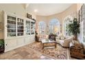 Cozy sitting room with arched windows, plantation shutters, and built-in bookcase at 10667 E Fanfol Ln, Scottsdale, AZ 85258