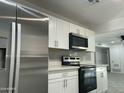 Updated kitchen featuring stainless steel appliances, white cabinets, and sleek countertops at 1851 E Palmcroft Dr, Tempe, AZ 85282