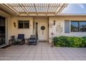 Covered patio with tile flooring, comfortable seating, and lush landscaping at 9725 W Oak Ridge Dr, Sun City, AZ 85351