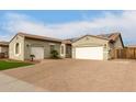 Two-car garage and paved driveway with a lush green lawn at 9982 W Villa Chula --, Peoria, AZ 85383