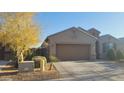 One-story home with a two-car garage, desert landscaping, and a paved driveway at 23793 W Ripple Rd, Buckeye, AZ 85326