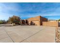 Exterior view of a stucco home with a three-car garage and a gated driveway at 4314 W Saguaro Park Ln, Glendale, AZ 85310