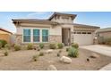 Charming single-story home with stone accents, a well-manicured lawn, and desert landscaping at 4711 N 212Th Dr, Buckeye, AZ 85396