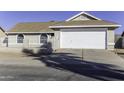 Front exterior of a house with a white garage door and palm tree shadows at 1748 E Shasta St, Casa Grande, AZ 85122