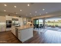 Modern kitchen with white cabinets, stainless steel appliances, and a large island at 36011 N Stoneware Dr, Queen Creek, AZ 85140