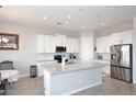 Kitchen with island, white shaker cabinets, stainless steel appliances, and dining area at 36023 N 140Th St, Scottsdale, AZ 85262