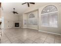 Living room with tile flooring, fireplace, ceiling fan, and large windows with blinds at 4202 E Broadway Rd # 40, Mesa, AZ 85206