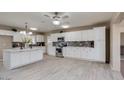 Updated kitchen boasts white cabinets, a large island, and wood-look floors at 142 W Ivanhoe Pl, Chandler, AZ 85225