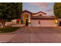 Inviting two-story home with a three-car garage and festive lighting at dusk at 2280 E Stephens Pl, Chandler, AZ 85225