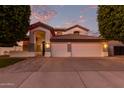 Inviting two-story home with a three-car garage and festive lighting at dusk at 2280 E Stephens Pl, Chandler, AZ 85225