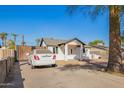 Front view of a single-story home with a driveway, landscaping, and palm trees at 2906 W Palm Ln, Phoenix, AZ 85009