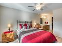 Bright bedroom with a red bedspread, wood furniture, and an ensuite bathroom at 14300 W Bell Rd # 501, Surprise, AZ 85374