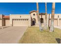 Spanish-style home with two-car garage and mature palm trees at 10214 E Michigan Ave, Sun Lakes, AZ 85248