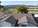 Aerial view of a house with a gray brick exterior, two-car garage, and a golf course view at 11642 S Half Moon Dr, Phoenix, AZ 85044