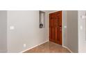 Bright and airy entryway with a rich wood door and tiled floor at 19522 N 84Th Ave, Peoria, AZ 85382