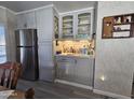 Convenient wet bar with gray cabinets and glass-front doors at 9302 E Broadway Rd # 184, Mesa, AZ 85208