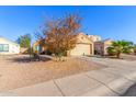 Tan house with a two-car garage and desert landscaping at 12322 W Larkspur Rd, El Mirage, AZ 85335