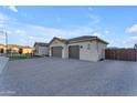 View of the home's side, showcasing a three-car garage and gated driveway at 21559 E Russet Rd, Queen Creek, AZ 85142