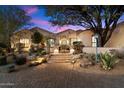 Beautiful two-story home with a brick pathway, lush landscaping, and desert plants at 25255 N Ranch Gate Rd, Scottsdale, AZ 85255