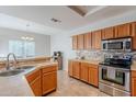 Bright kitchen with stainless steel appliances and wood cabinets at 10051 E Carmel Ave, Mesa, AZ 85208