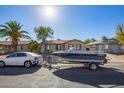 Tan house with boat parked in the driveway and a car parked on the street at 5209 W Mauna Loa Ln, Glendale, AZ 85306