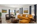 Bright and spacious living room with mustard colored sofa and two armchairs at 25332 W Sunland Ave, Buckeye, AZ 85326