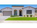Single-story home with stucco exterior, arched entryway, and artificial turf at 11899 N Spearfish St, Surprise, AZ 85388