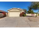 Tan house with a two-car garage and red flowering bushes at 2628 E Beverly Rd, Phoenix, AZ 85042