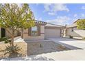 One-story house with tan exterior, brown shutters, and a two-car garage at 40925 W Patricia Ln, Maricopa, AZ 85138