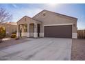 Modern one-story home with a brown garage door and driveway at 1241 E Paul Dr, Casa Grande, AZ 85122