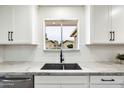 Modern kitchen sink with marble countertops and a view from the window at 10404 W Audrey Dr, Sun City, AZ 85351