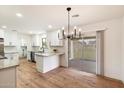Modern kitchen with white cabinets, an island, and access to a patio at 10404 W Audrey Dr, Sun City, AZ 85351
