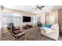 Bright living room featuring a TV, comfortable seating, and large windows at 7318 W Greer Ave, Peoria, AZ 85345