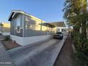 Gray manufactured home with carport and parking area at 821 W Kachina Trl, Phoenix, AZ 85040
