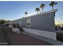 Gray manufactured home with deck and stairs, surrounded by desert landscaping at 821 W Kachina Trl, Phoenix, AZ 85040