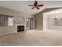 Spacious living room with a fireplace, sliding glass door, and ceiling fan at 15050 N Thompson Peak Pkwy # 2006, Scottsdale, AZ 85260