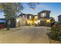 Two-story house with a three-car garage and landscaped front yard at dusk at 14575 W Orange Dr, Litchfield Park, AZ 85340