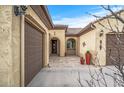 Front courtyard entry with tile flooring, potted plants, and arched entryways at 18852 N 260Th Ln, Buckeye, AZ 85396